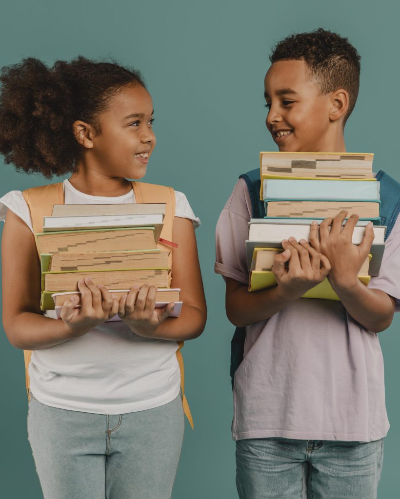 children-holding-piles-books